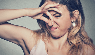 Woman pinching her nose at a bad smell